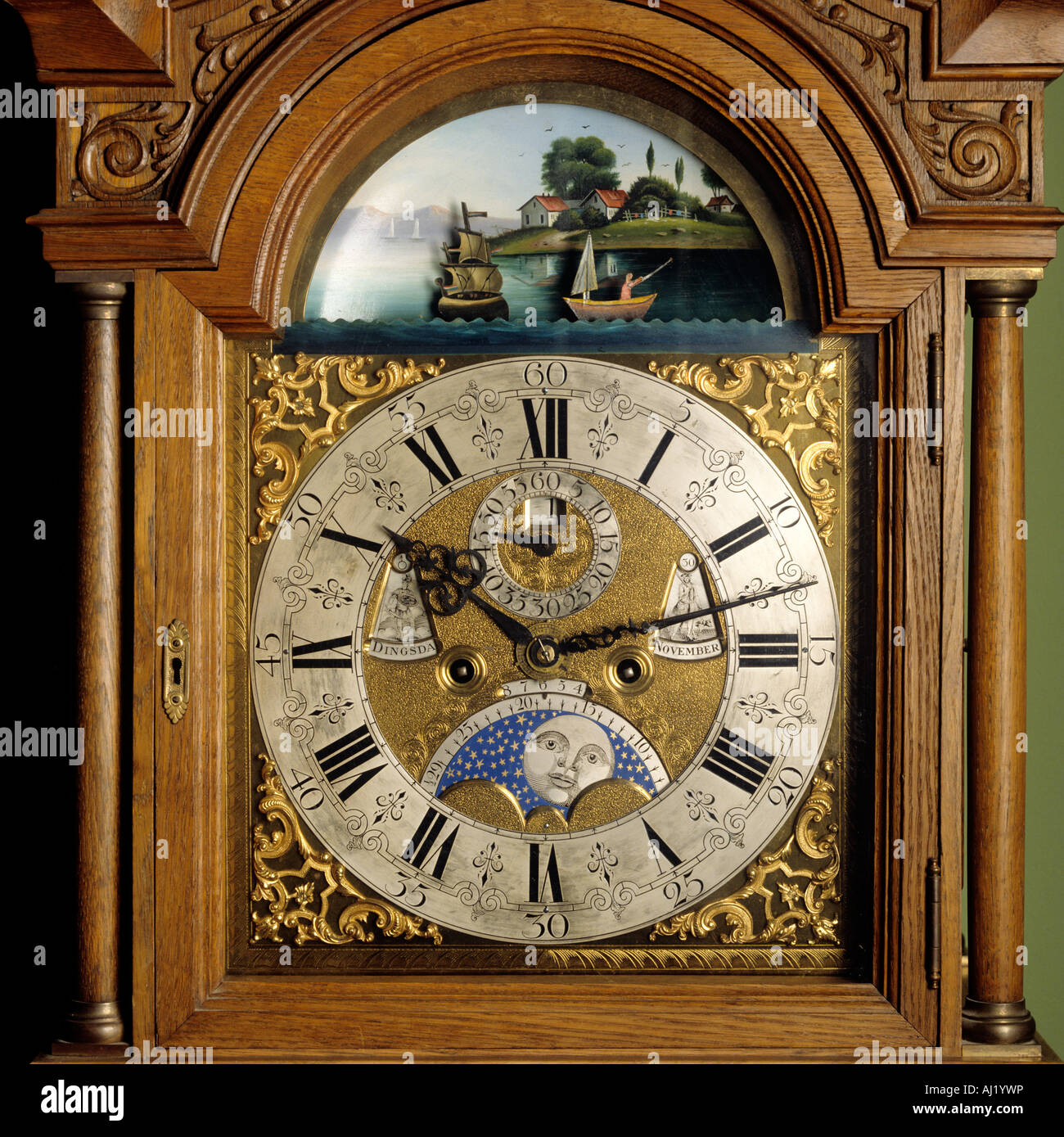 Wooden grandfather clock face with roman numerals, decorative images and moondial Stock Photo