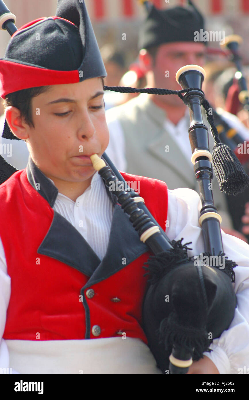 Young man playing the bagpipe with traditional Asturian costume during