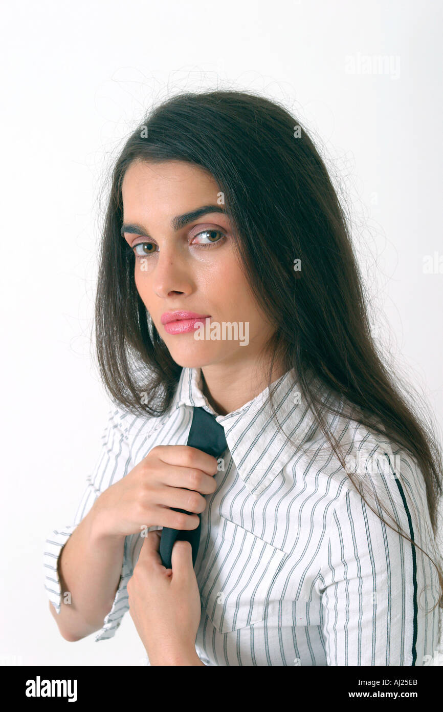 Young woman with long black hair straightening up her tie Stock Photo -  Alamy