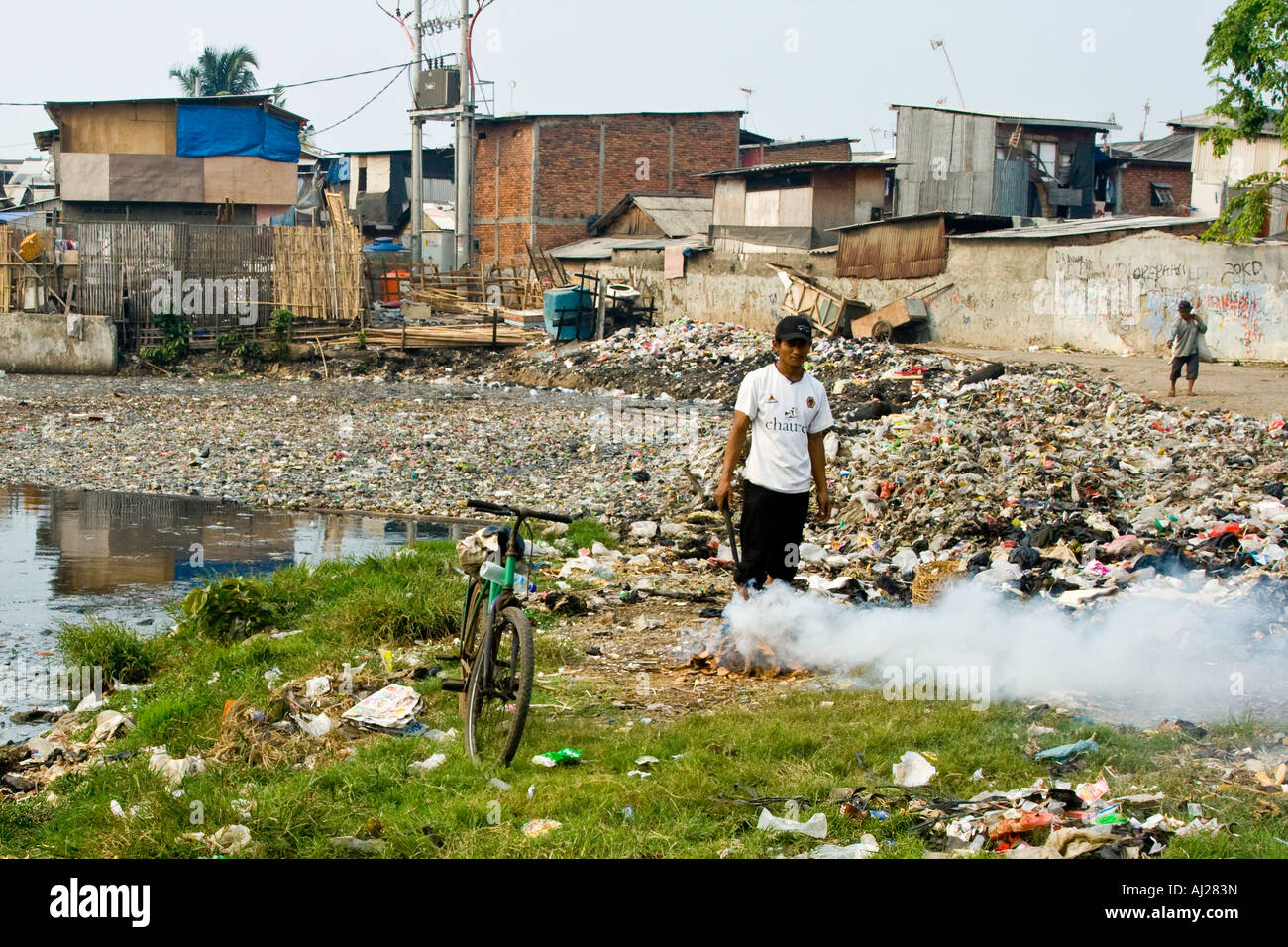 Burning Rubbish on the Garbage Heap Bordering a Poor Neighborhood Slum Jakarta Indonesia Stock Photo