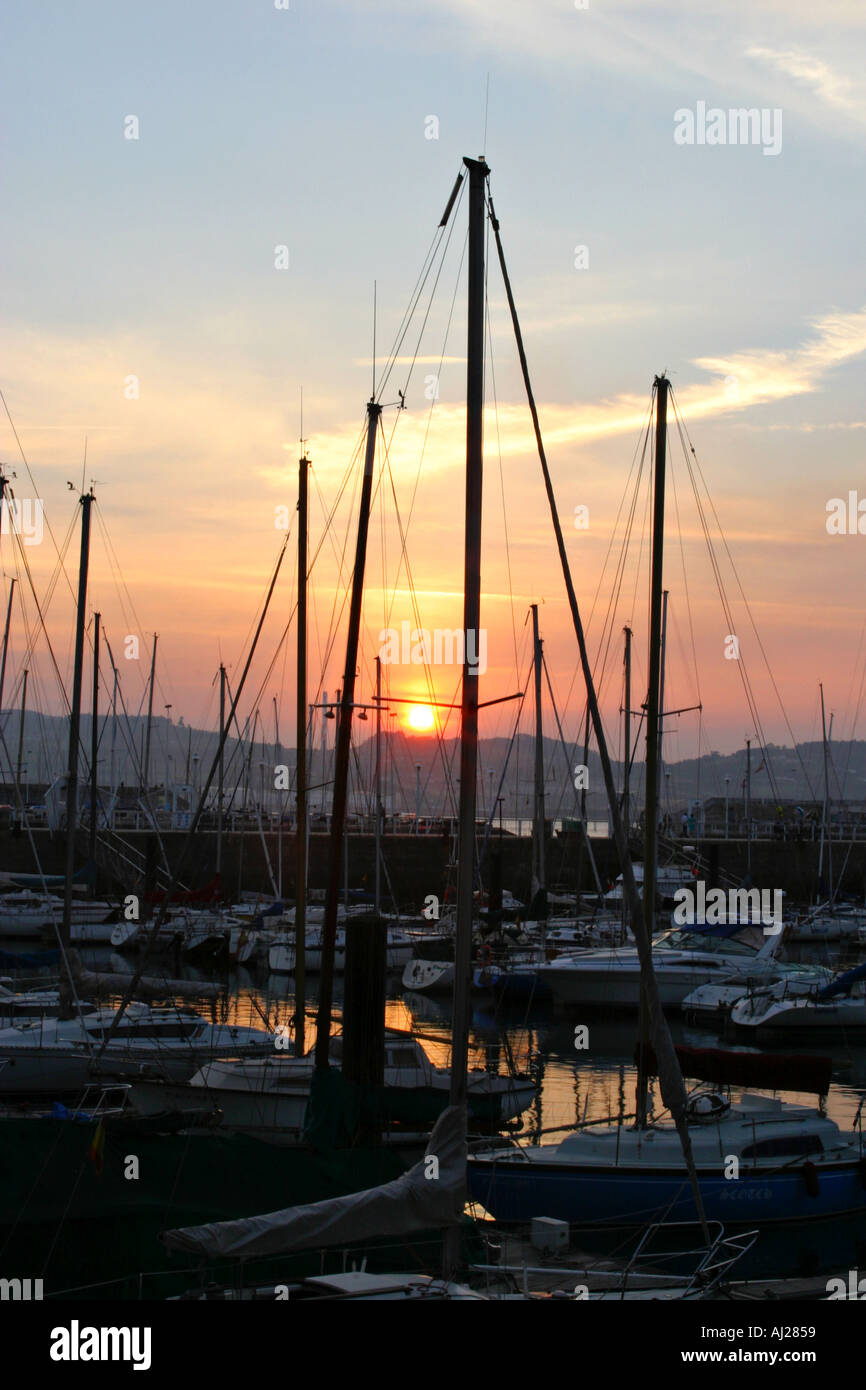 Image showcasing Sundown behind the masts of moored boats Stock Photo - Alamy