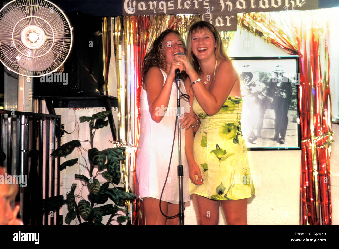 Young English women singing at karaoke bar in Tenerife, Spain Stock Photo