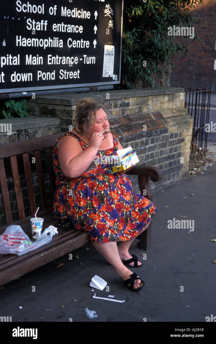 Obese woman eating fast food chicken takeaway, London England UK Stock Photo