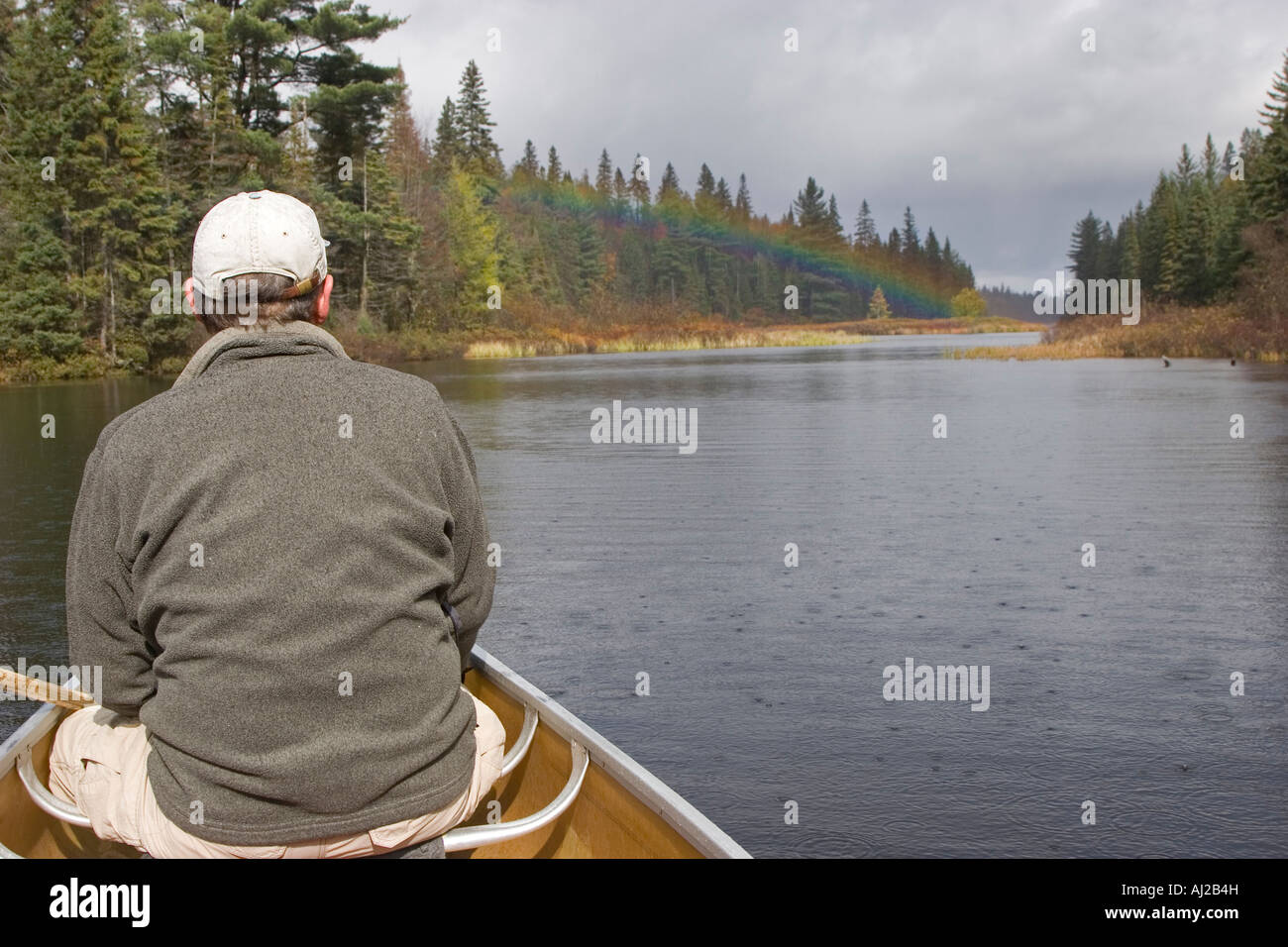 Canoe on Rain Lake with rainbow in Algonquin Provincial Park Stock Photo