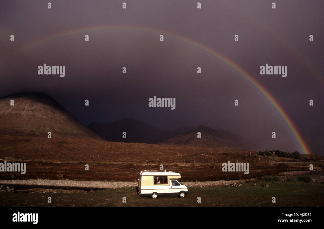 RV Auto Sleeper Clubman family camper van lit by sunshine framed by rainbow on a campsite in the Cuillin mountains Sligachan Isle of Skye Scotland UK Stock Photo