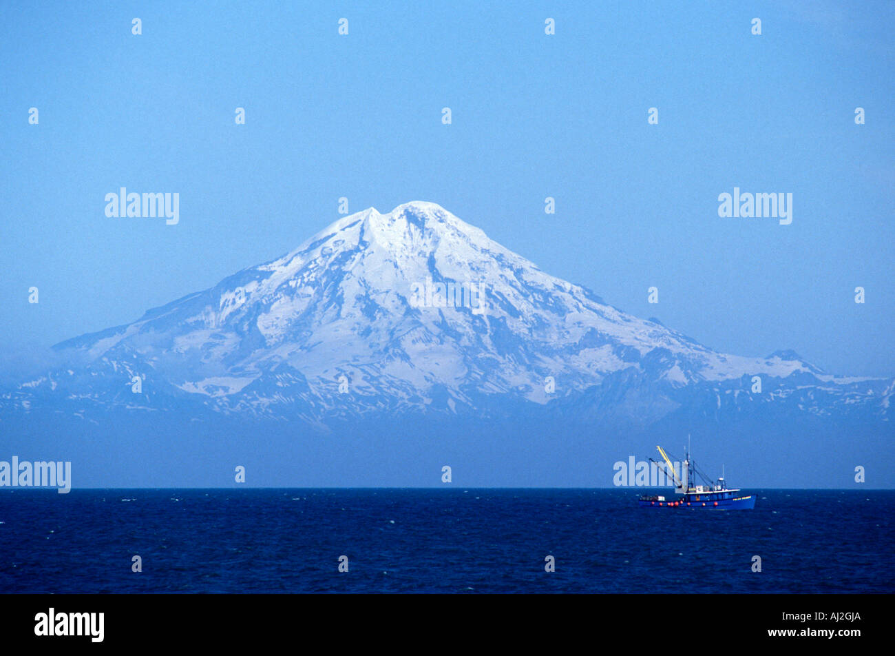 USA Alaska Ninilchik Fishing trawler motors past Redoubt Volcano in Cook along Kenai