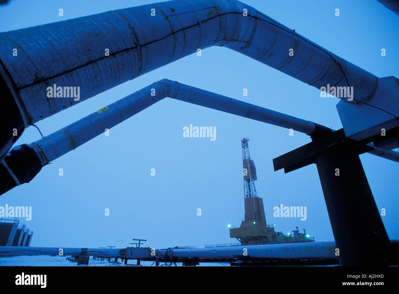 USA Alaska Oil well drilling rig and pipelines in winter twilight in BP oilfield near Prudhoe Bay Stock Photo