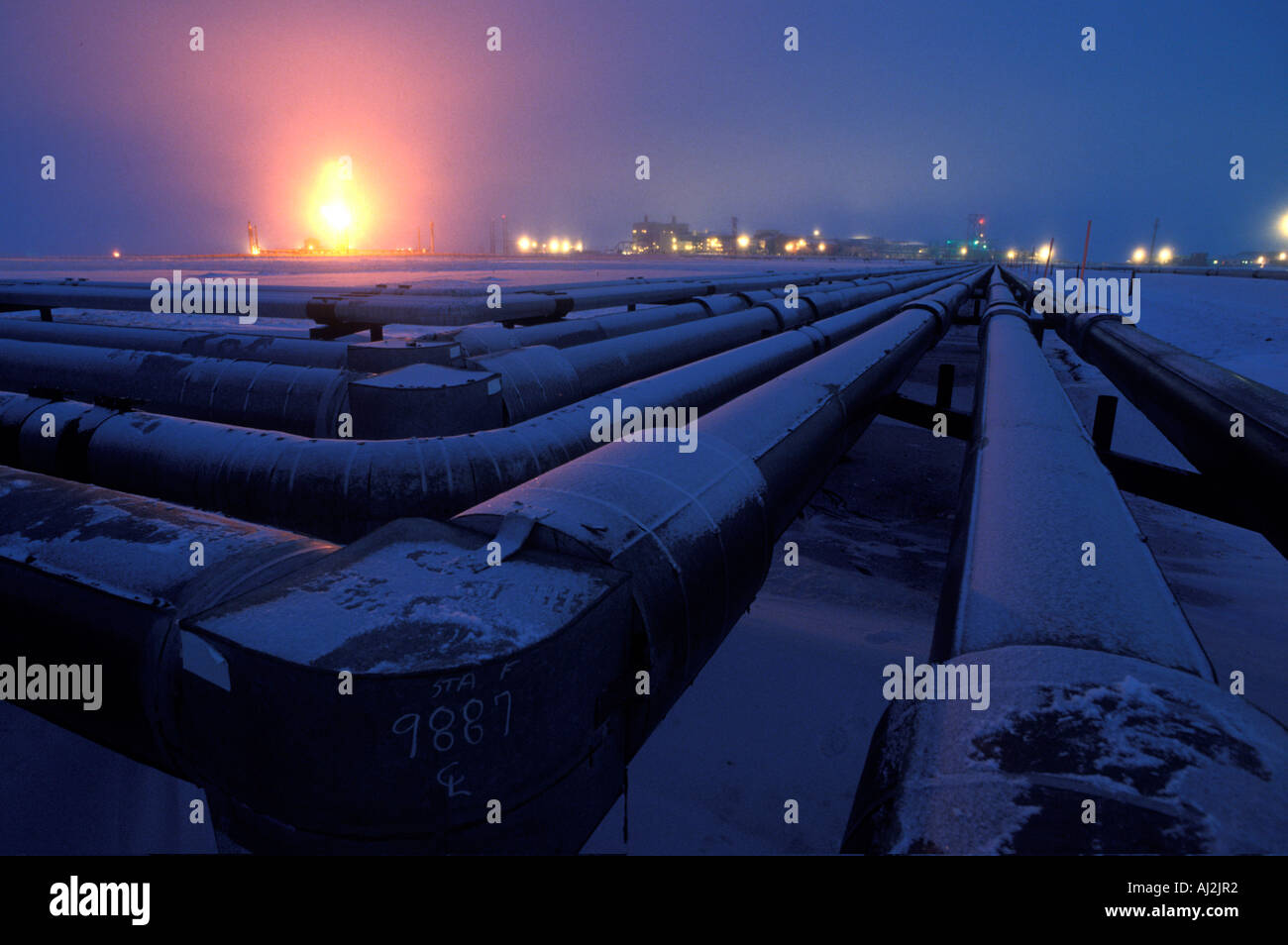 USA Alaska Gas flare lights pipeline and twilight winter sky at Prudhoe Bay oil fields in early winter Stock Photo