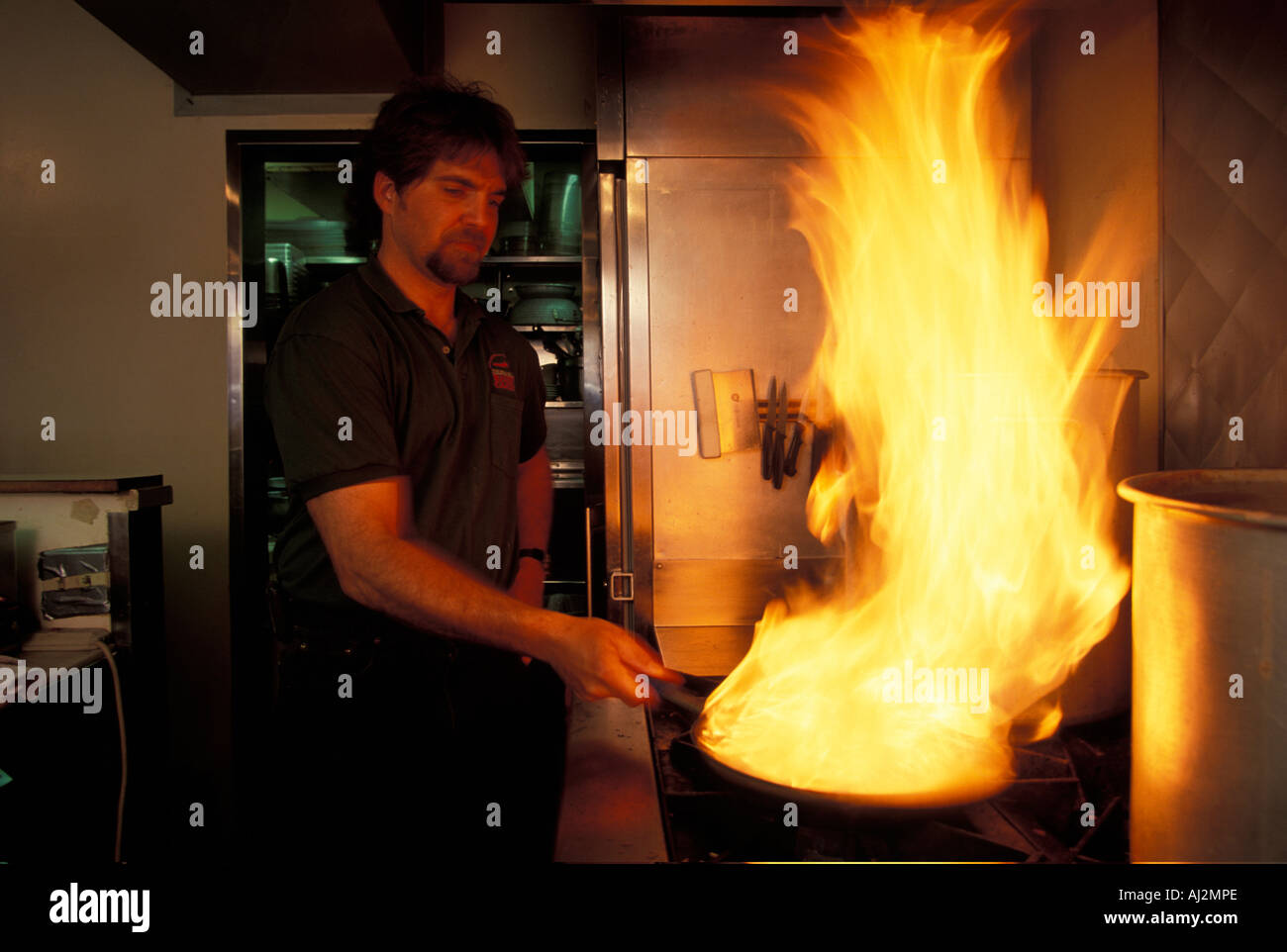 USA Washington Seattle Danny Delhambra sends up flames while cooking at Ragin Cajun Restaurant Stock Photo