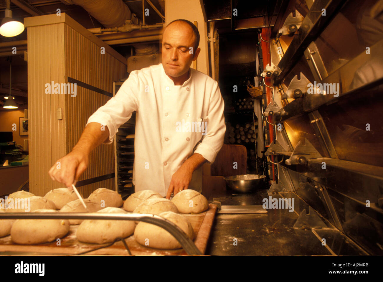 USA Washington Seattle Thierry Mougin pulls freshly baked loaves of bread  from oven at Le Panier in Pike Place Market Stock Photo - Alamy