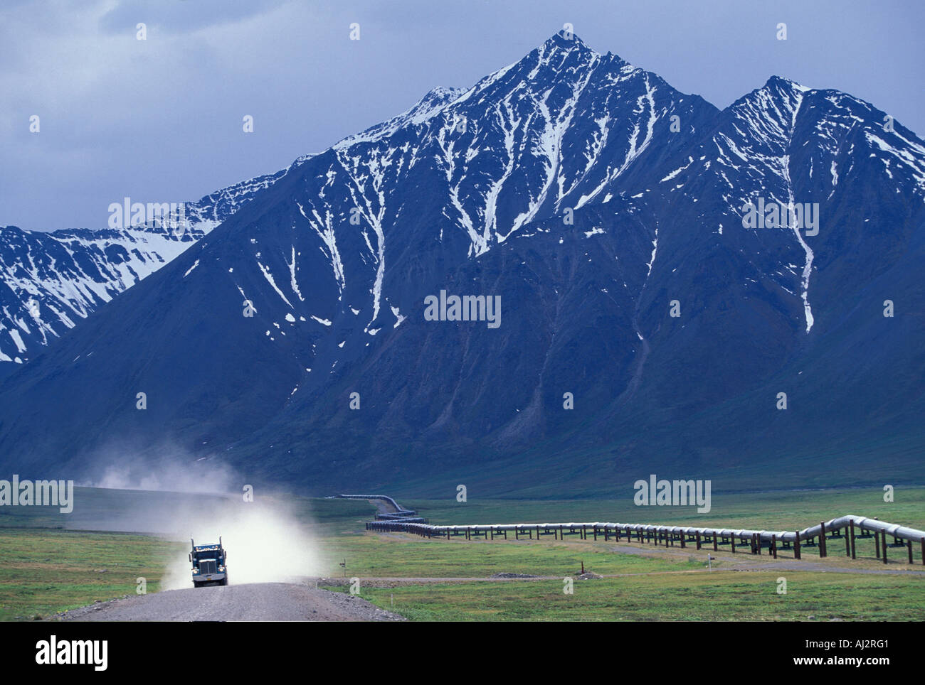 USA Alaska Truck drives leaves plume of dust while driving on gravel covered Dalton Highway north of Atigun Pass Stock Photo