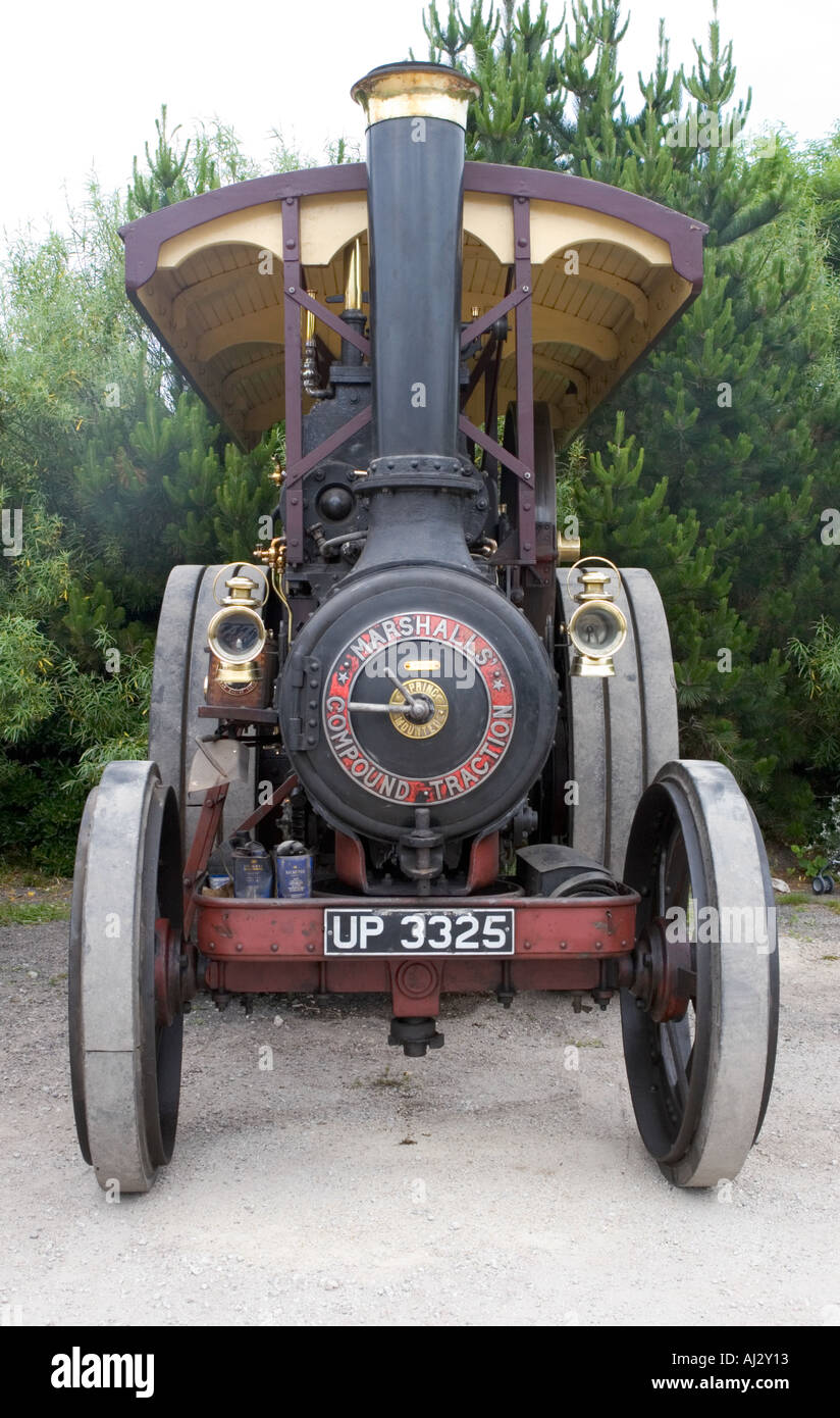Front view of a steam powered traction engine against a backdrop of