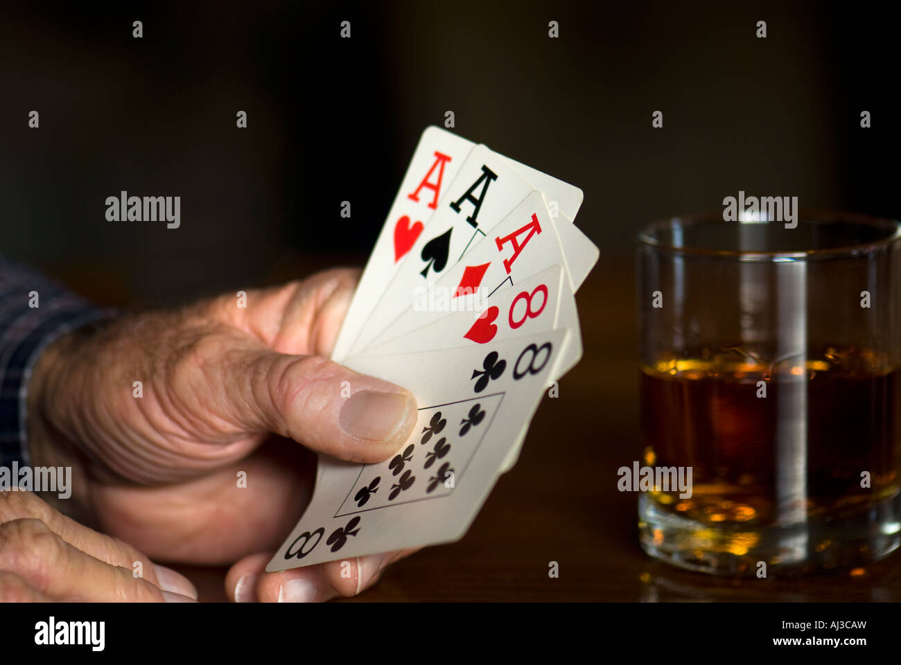 Caucasian man’s hand holding a poker hand of playing cards.  USA. Stock Photo