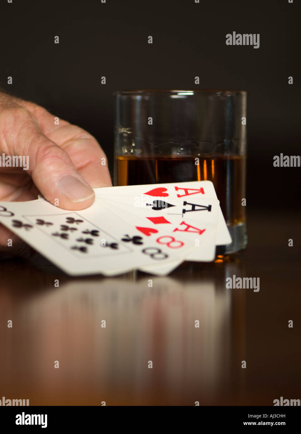 Caucasian man’s hand holding a poker hand of playing cards. USA Stock
