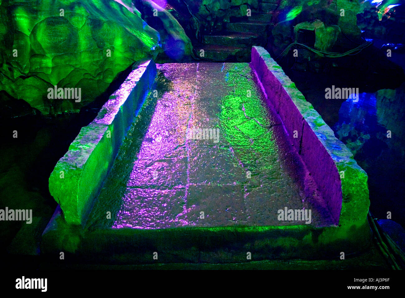 A green colored bridge crosses a river in the Reed Flute Cave in Guilin China Stock Photo