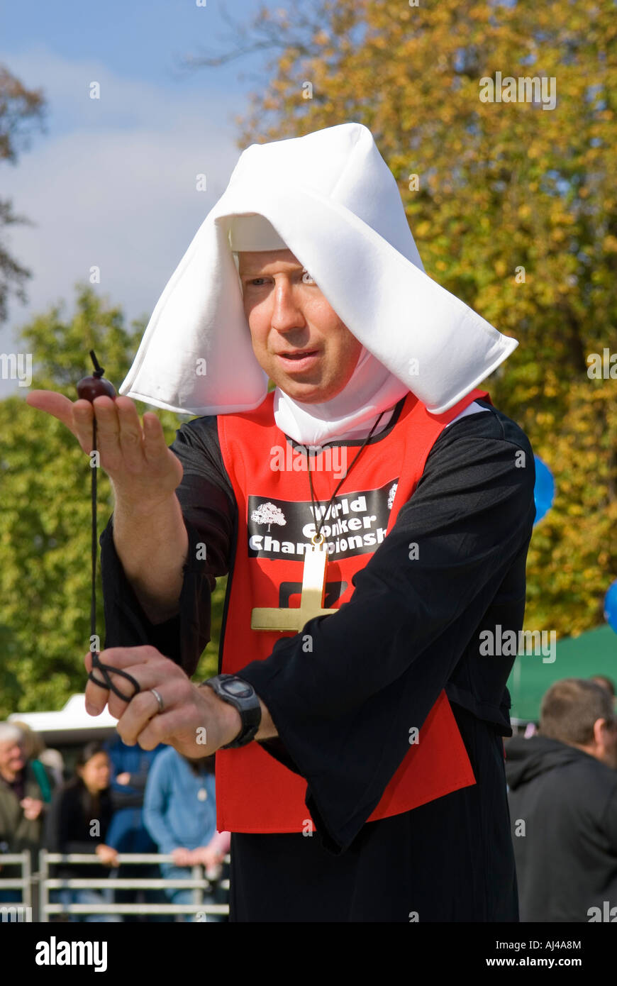 Man dressed as Nun playing conkers at the World Conker Championships Stock Photo