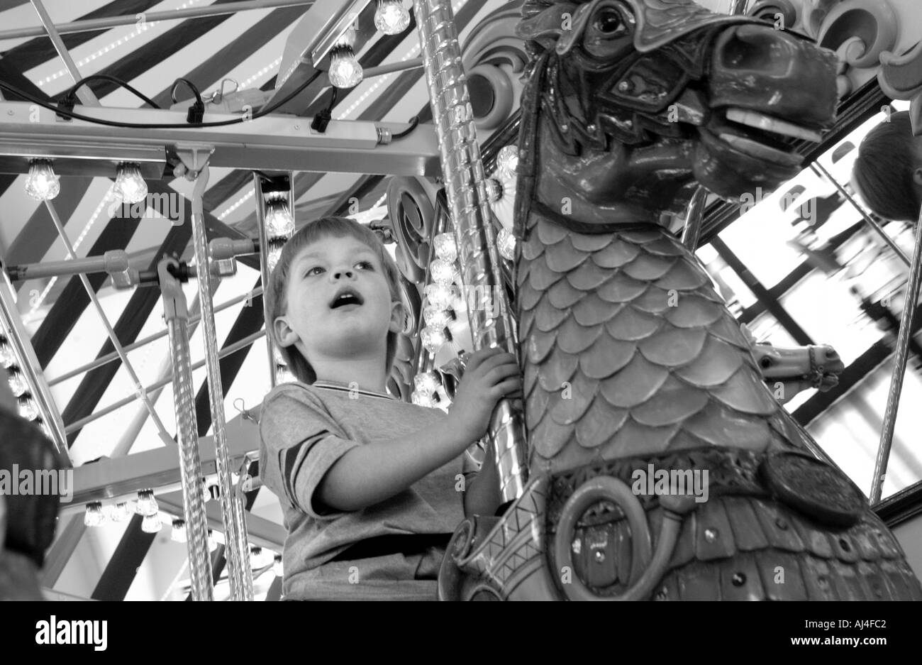 Young boy rides Carousel Stock Photo