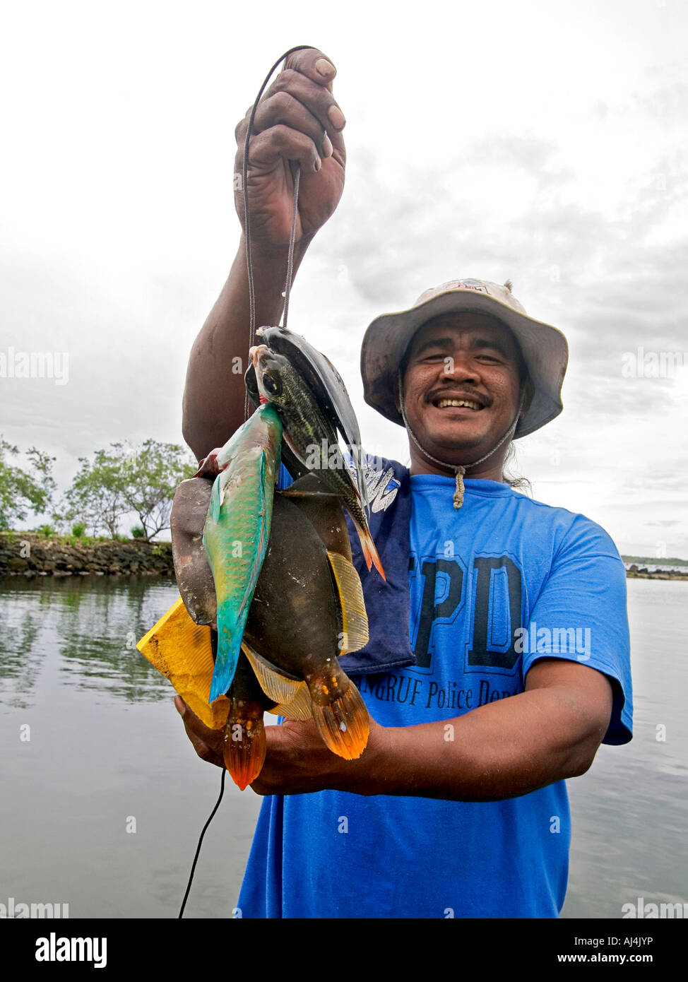 Local man holds string of fish he caught while snorkeling in Kosrae Federated States of Micronesia FSM Stock Photo