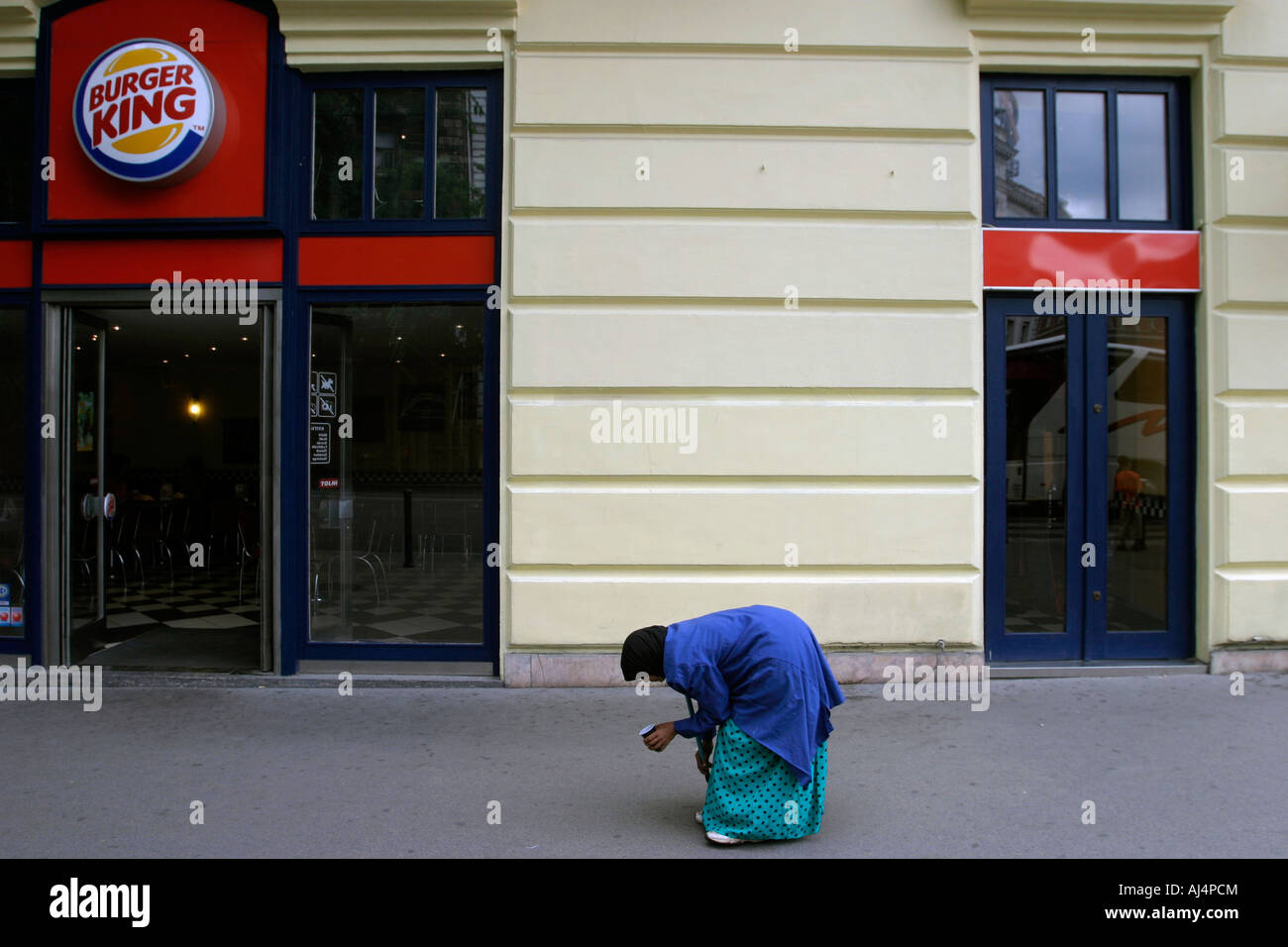 Bent old woman walking on the street begging Budapest Hungary Stock Photo
