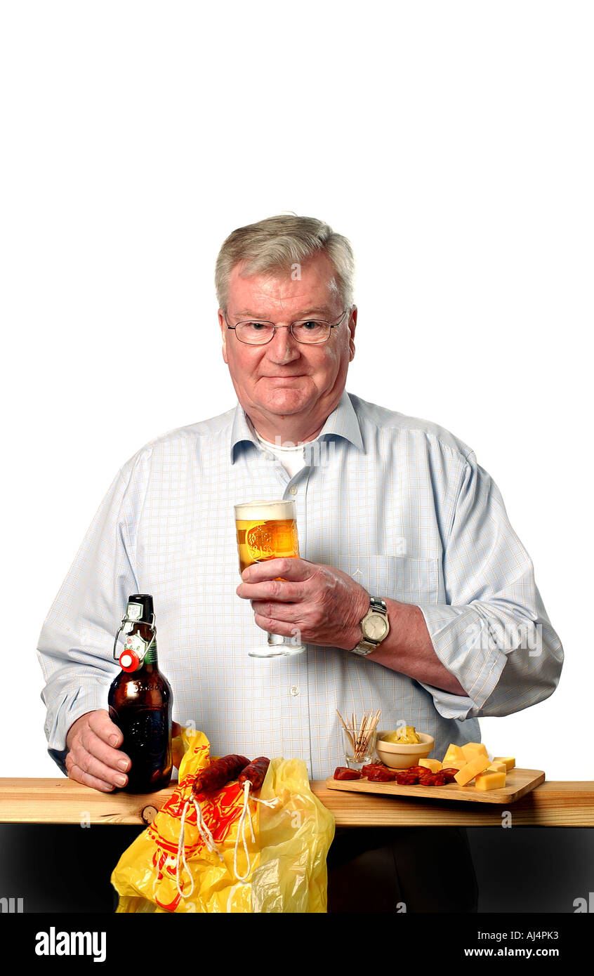 Older man drinking cold grolsch beer with bottle, glass and a plate with cheese and mustard. Stock Photo