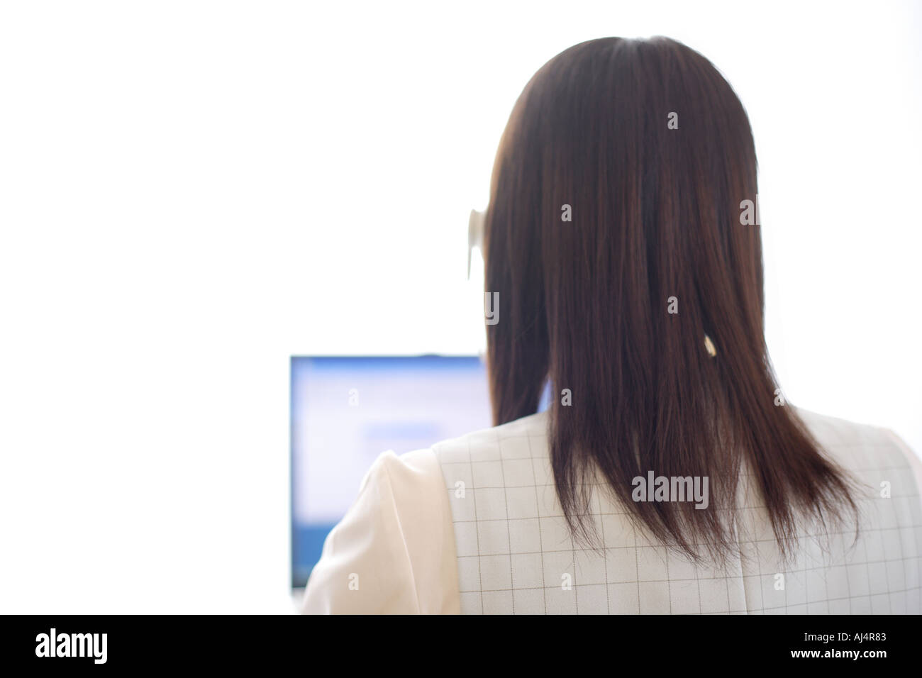 Woman on computer rear view Cut Out Stock Images & Pictures - Alamy