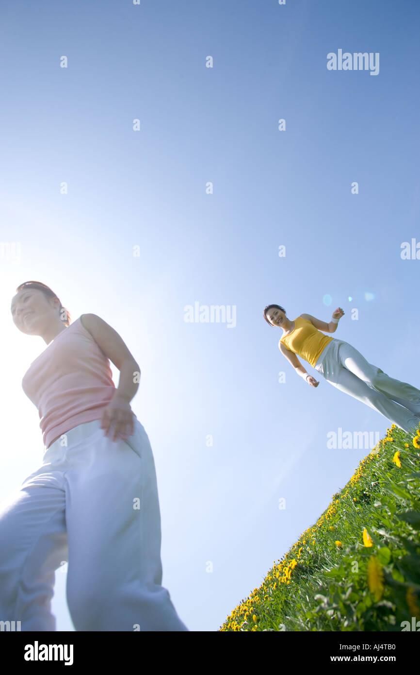 Two young Woman walking in field Stock Photo