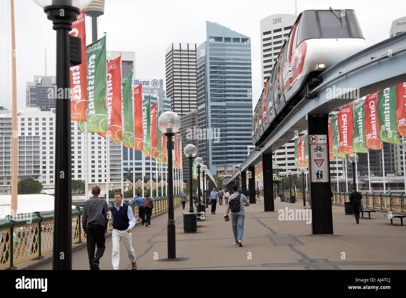 People walking over Pyrmont Bridge with Christmas decorations on a grey summer day in Sydney New South Wales NSW Australia Stock Photo