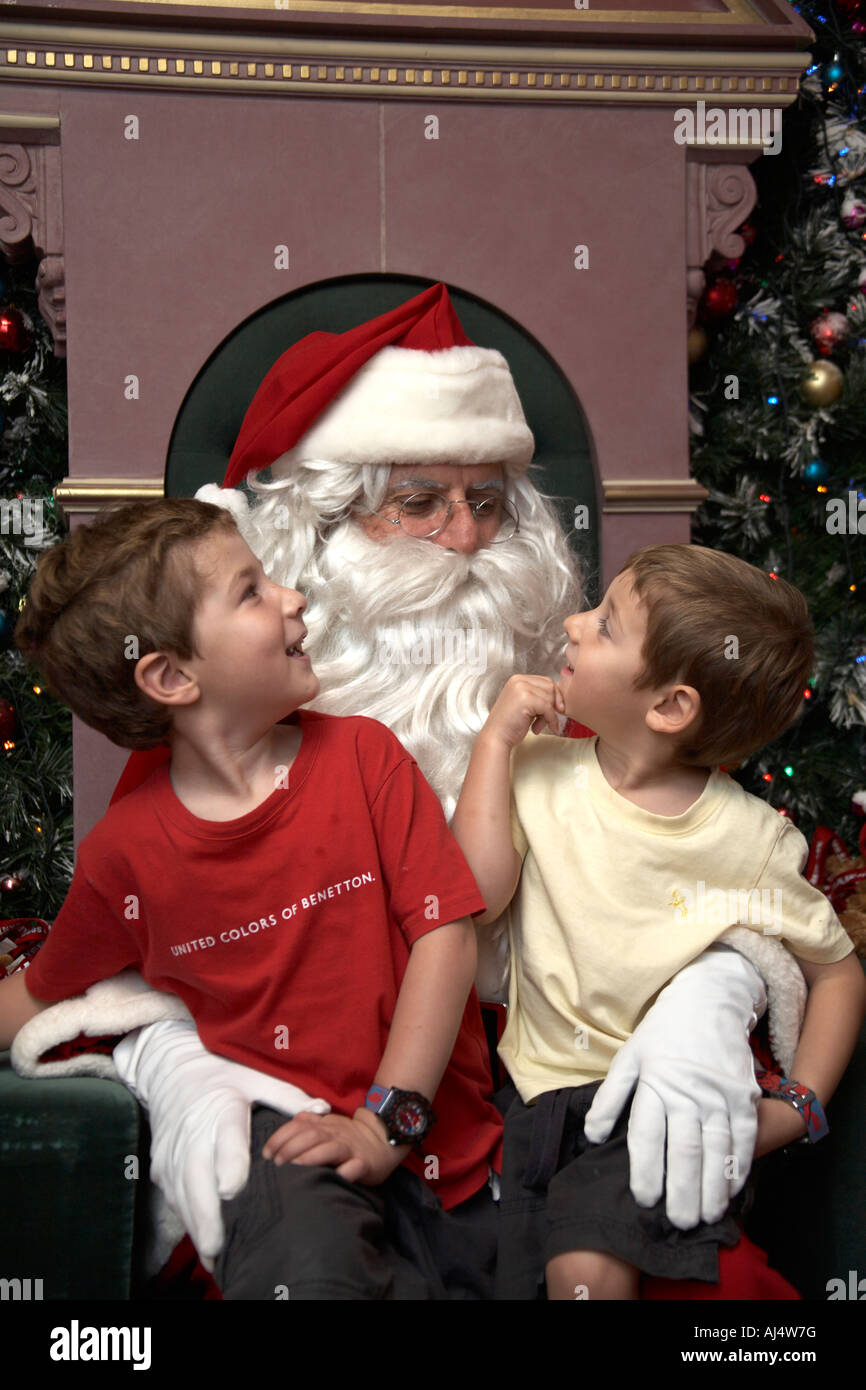 Father Christmas or Santa Claus with red hat white beard and two young boys children in Sydney New South Wales NSW Australia NA Stock Photo