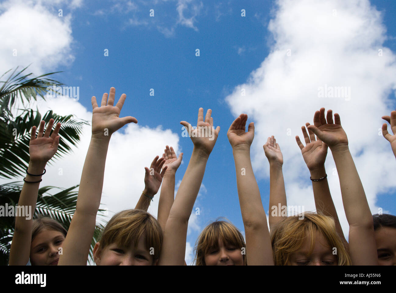 Children with arms in the air Kauai Hawaii Stock Photo