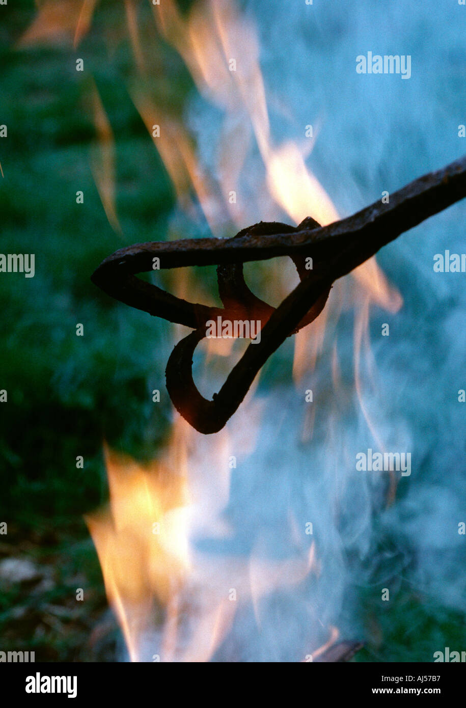 Heating branding iron in campfire Stock Photo Alamy