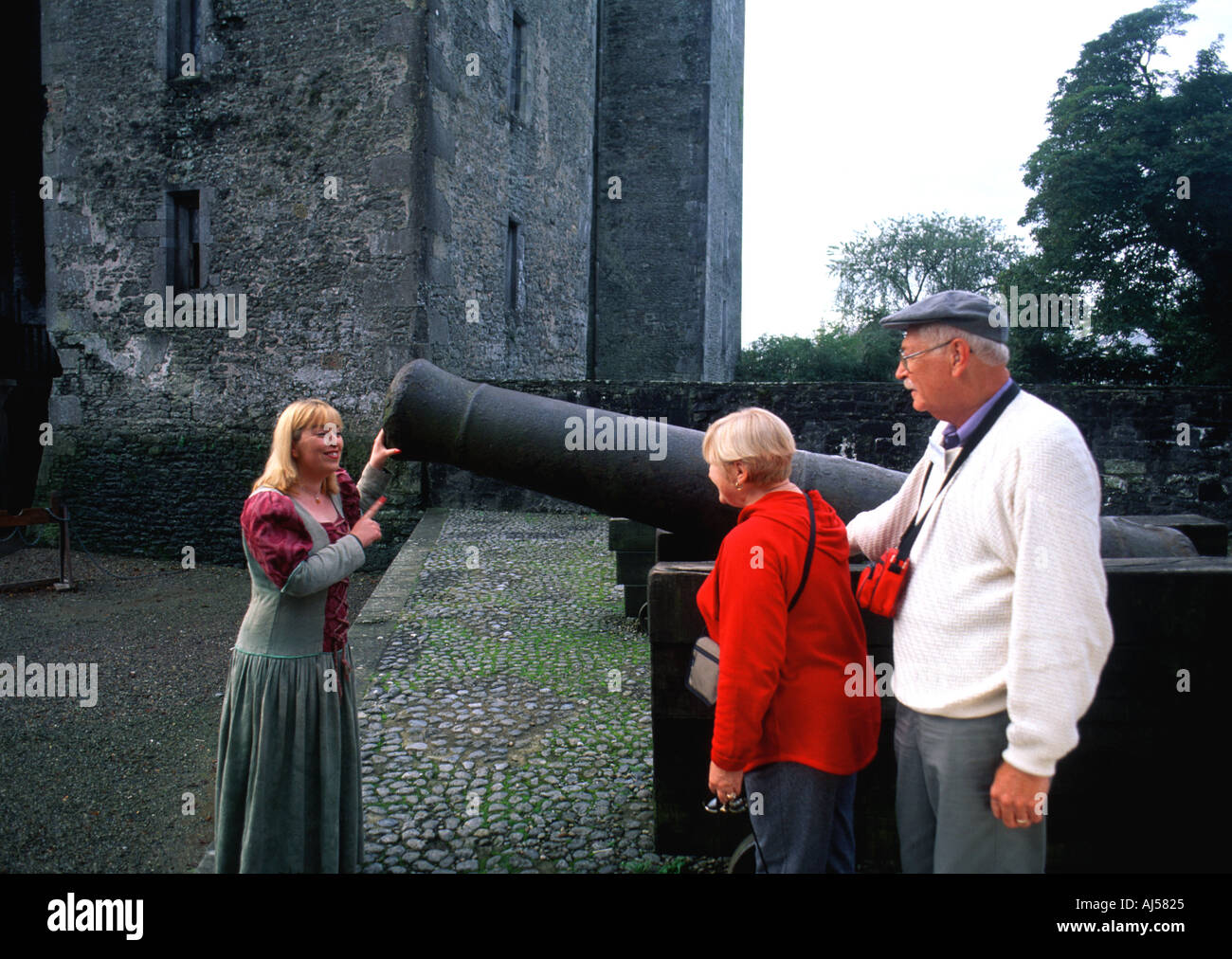 Retired Tourist Couple with Costumed Woman near Cannon at Bunratty Castle Ennis Ireland Stock Photo