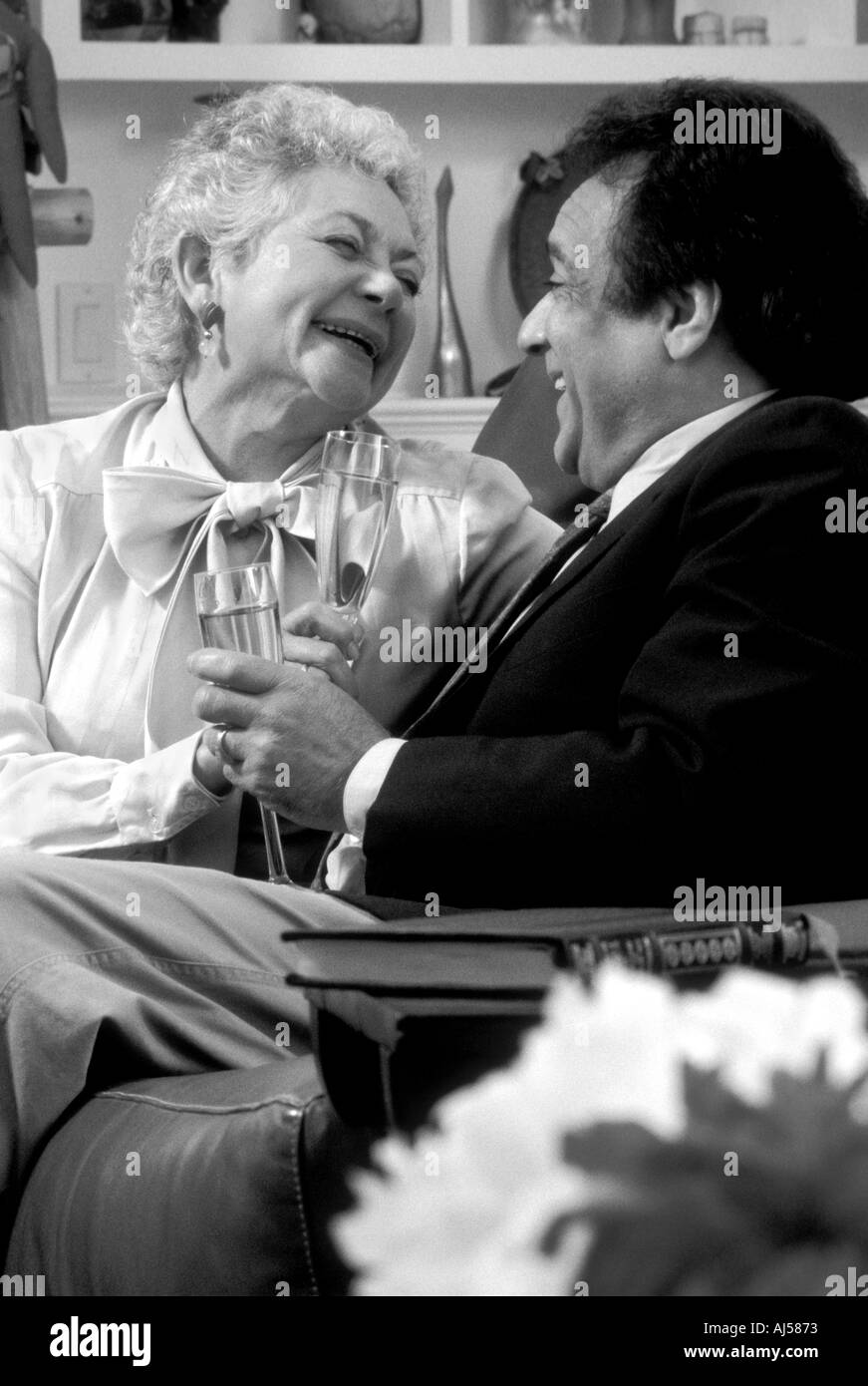 Black and white senior Latino couple toasting anniversary Stock Photo