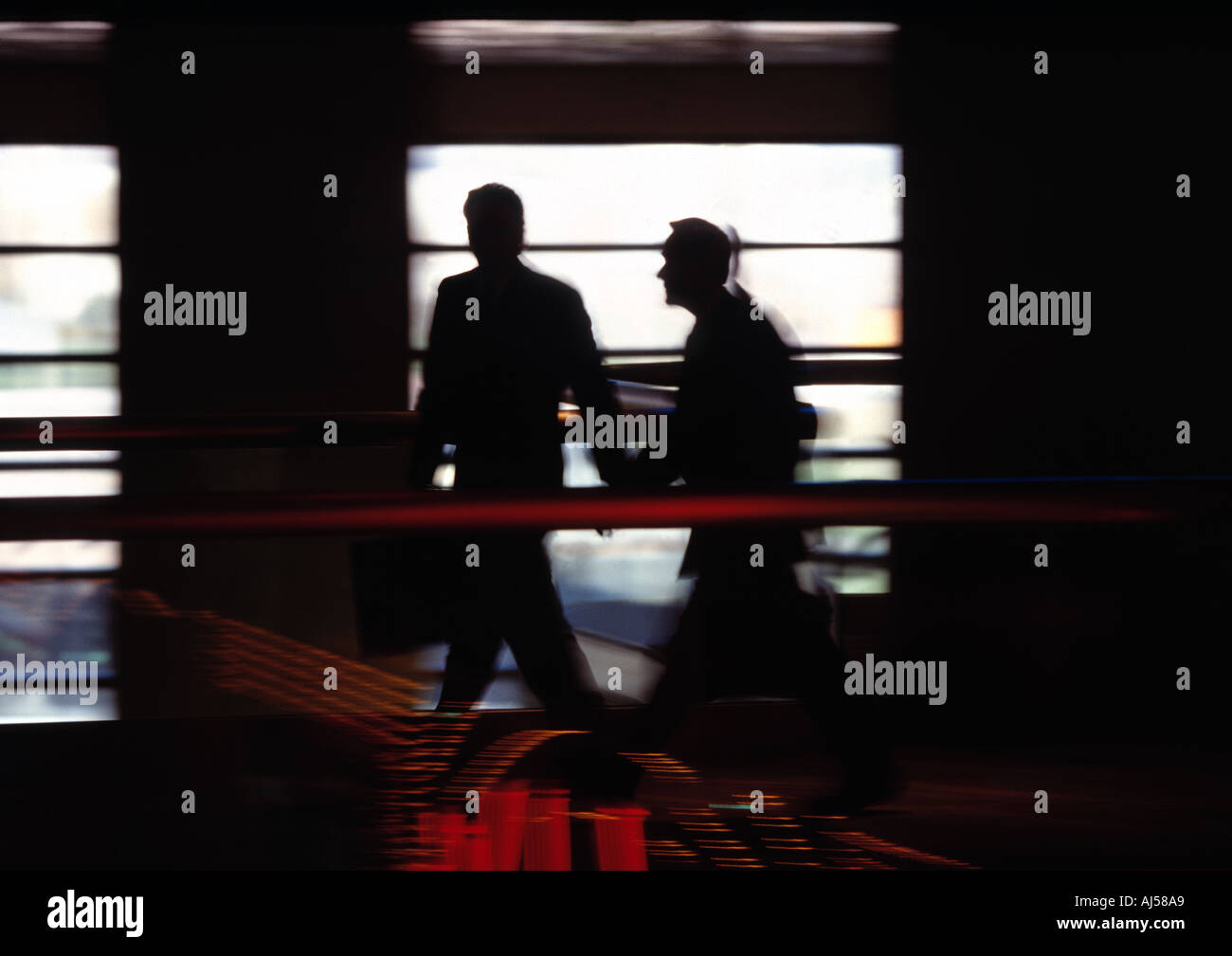 Silhouette of executives talking business while walking in hallway Stock Photo