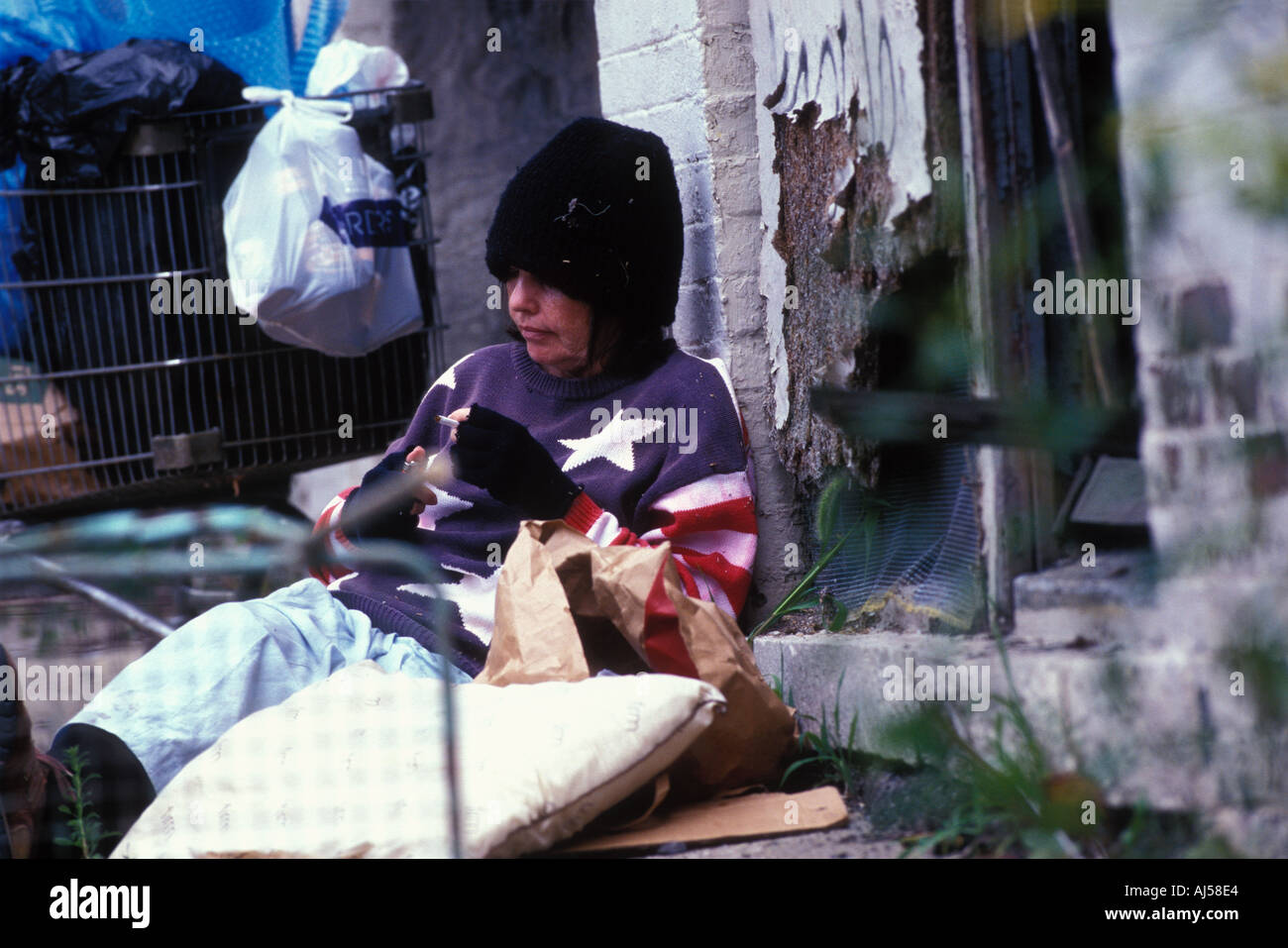 Homeless woman sitting on street staged photograph with actor Stock Photo