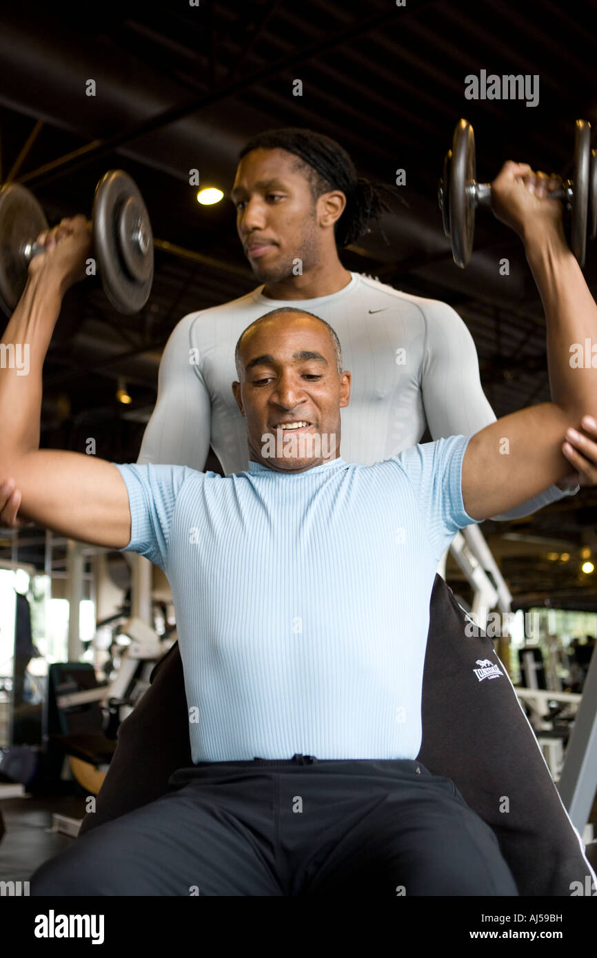 two 2 fit fitness males men exercising in a gym shoulder workout