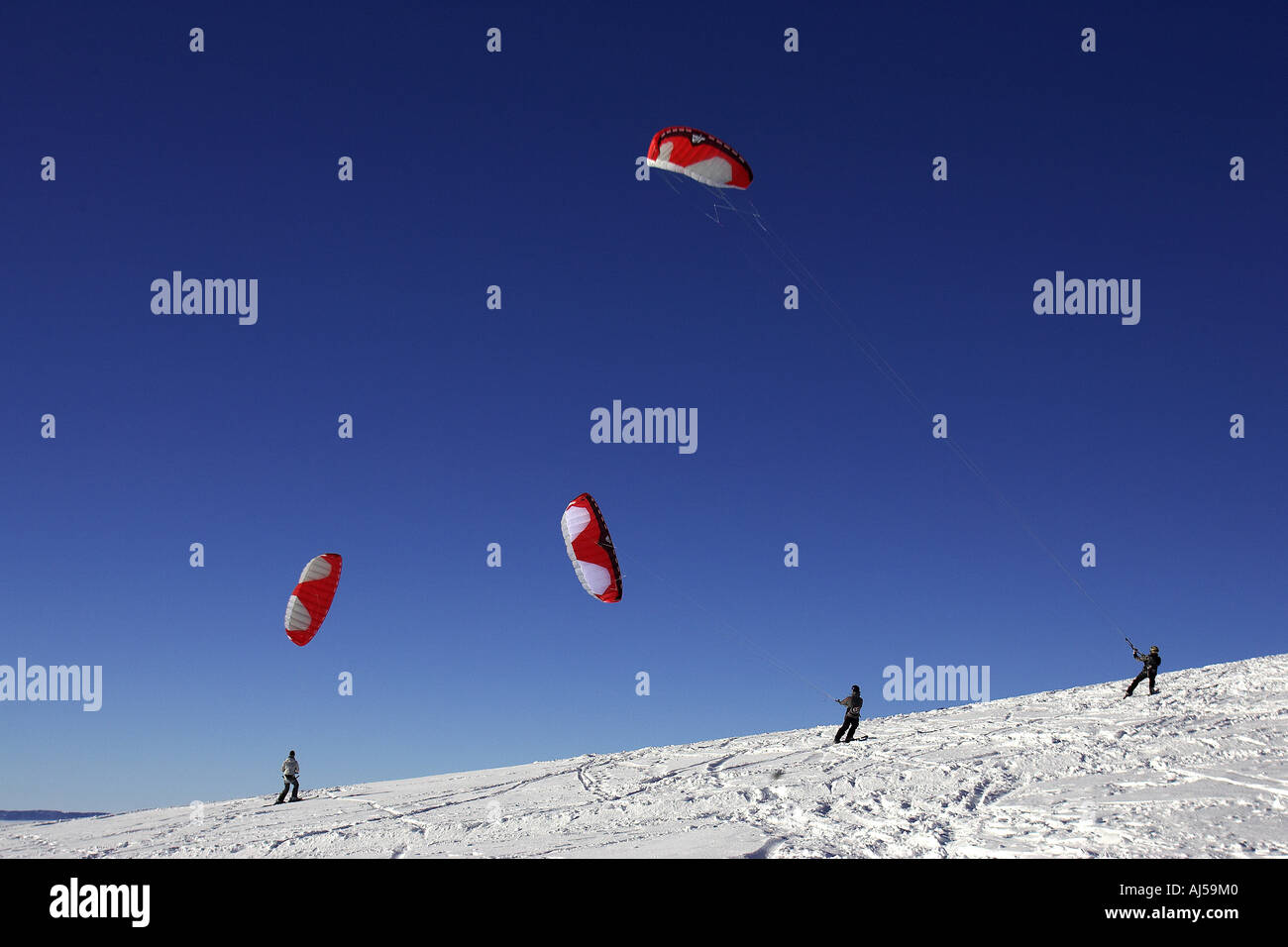 three snow kiters in Semnoz French Alps. Stock Photo
