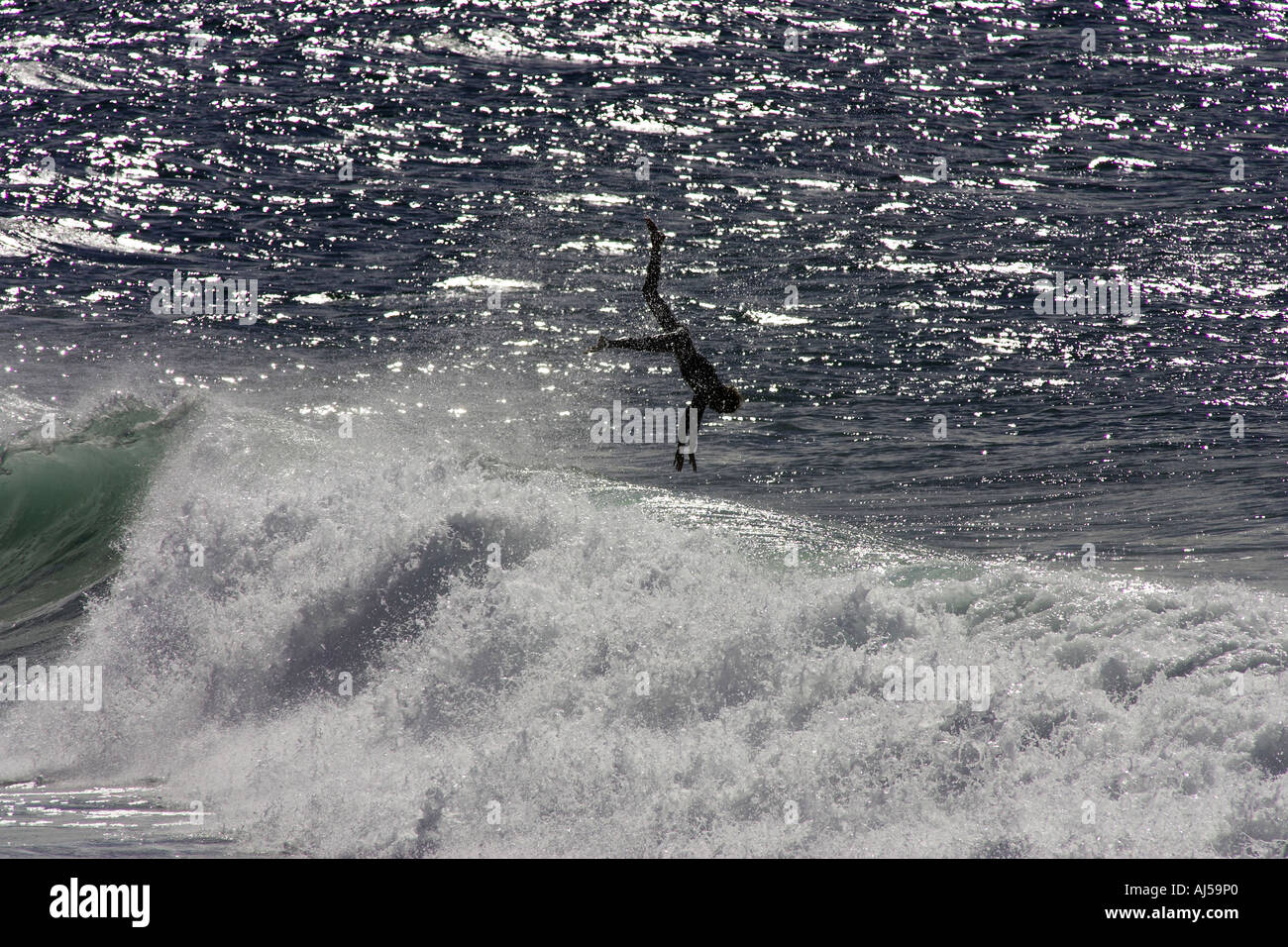 Surfer dives over wave Stock Photo