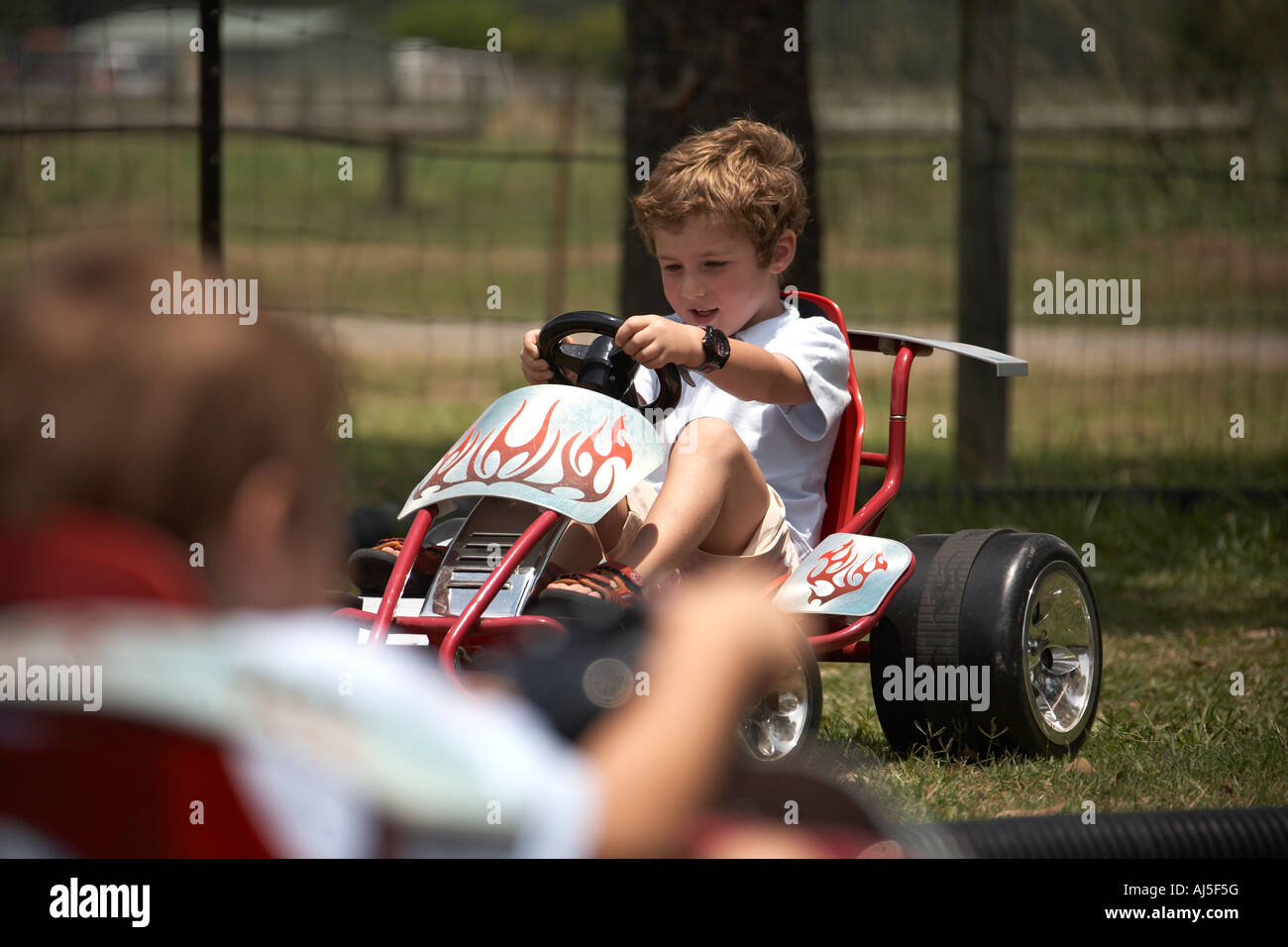 Young boys children driving Go Karts outdoors in Coffs Harbour in New South Wales NSW Australia NAOH CJWH Stock Photo
