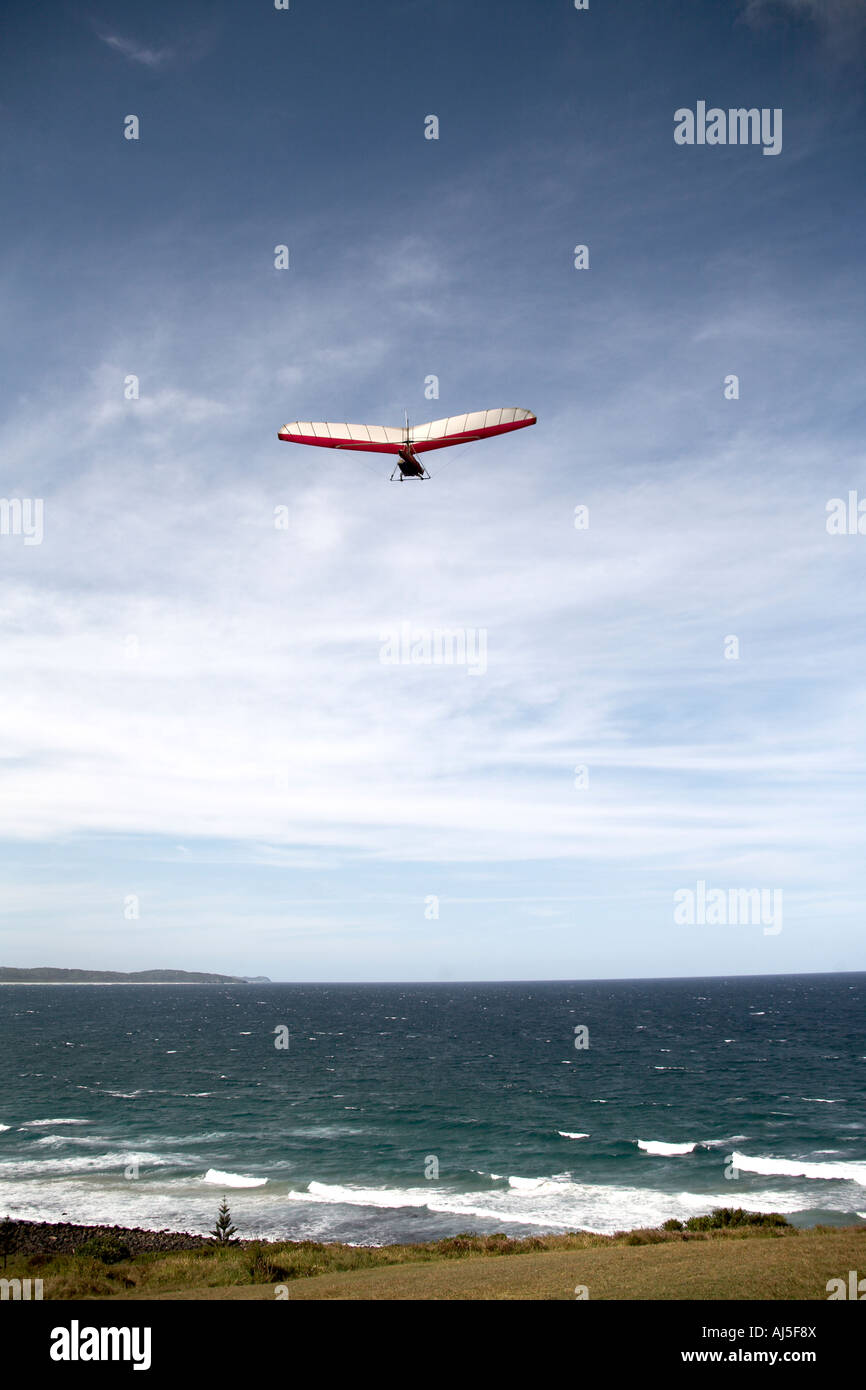 Tandem hang glider pilot flying hang gliding with passenger in sky from ridge by sea near Lennox Head in New South Wales NSW Stock Photo