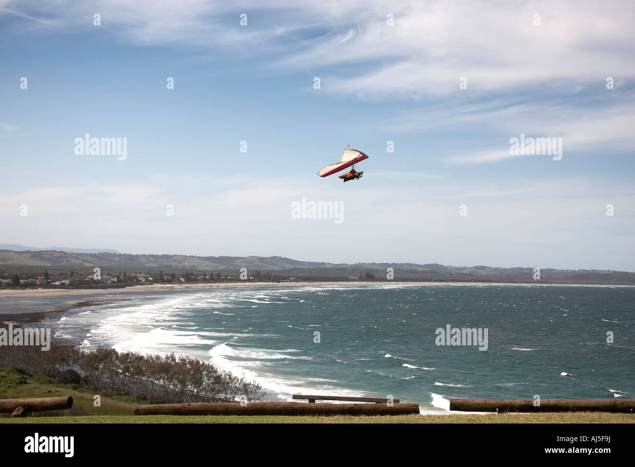 Tandem hang glider pilot flying hang gliding with passenger in sky from ridge by sea near Lennox Head in New South Wales NSW Stock Photo
