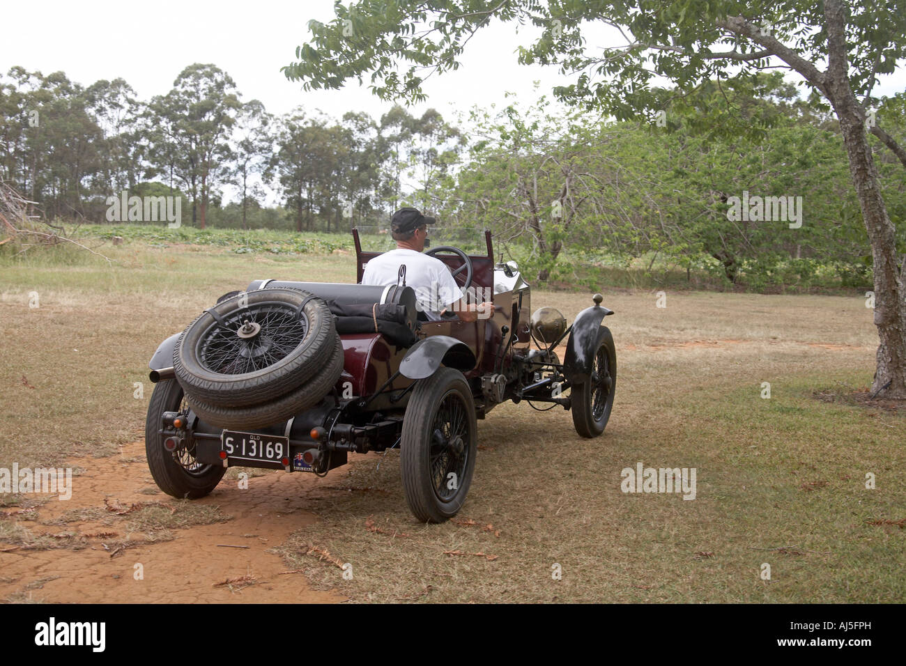 Old vintage Vauxhall motor car being driven on dirt track outdoors in Queensland QLD Australia Stock Photo