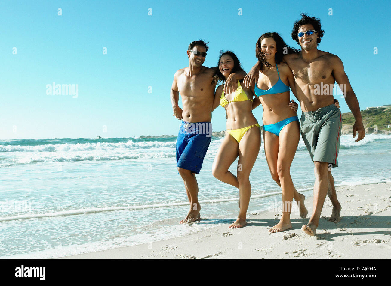 Young couples walking on beach Stock Photo - Alamy