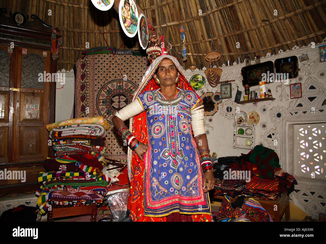 Harijan Tribal woman surrounded by stock of handicrafts and embroidery in her mud hut in Ludia Village, nr Khavda, Kutch district, Gujarat, India Stock Photo