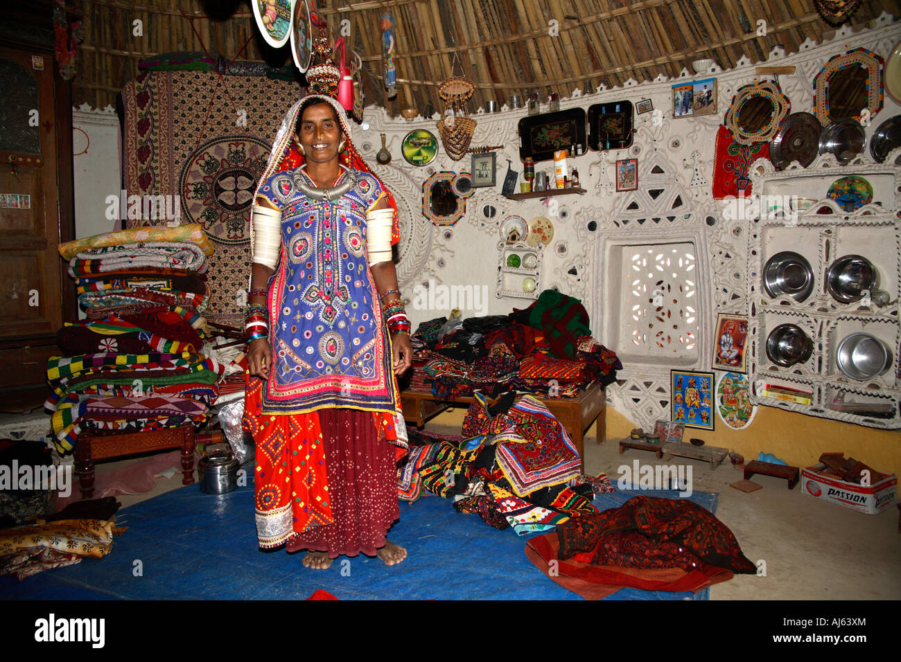 Harijan Tribal woman surrounded by stock of handicrafts in her mud hut, Ludia Village, nr Khavda, Kutch district, Gujarat, India Stock Photo
