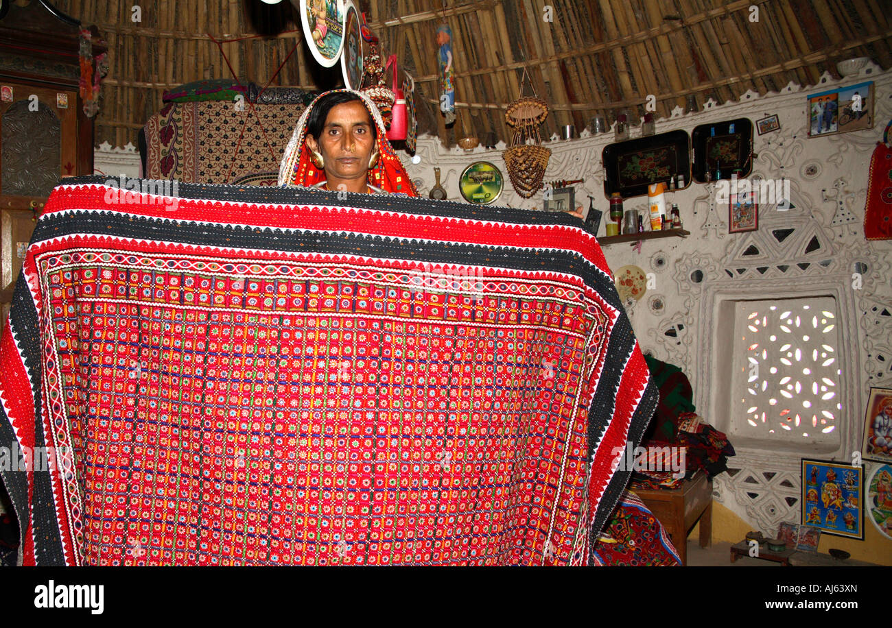 Harijan Tribal woman displaying large embroidered quilt in Ludia Village, nr Khavda, Kutch district, Gujarat, India Stock Photo