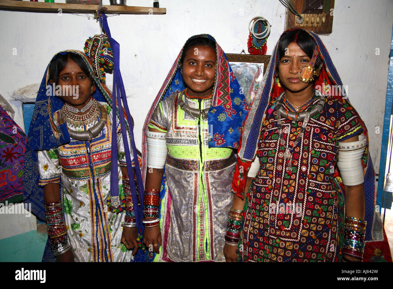 Two pretty Harijan tribal girls beside married woman with large nose ring in Ludia Village, nr Khavda, Kutch district, Gujarat, India Stock Photo