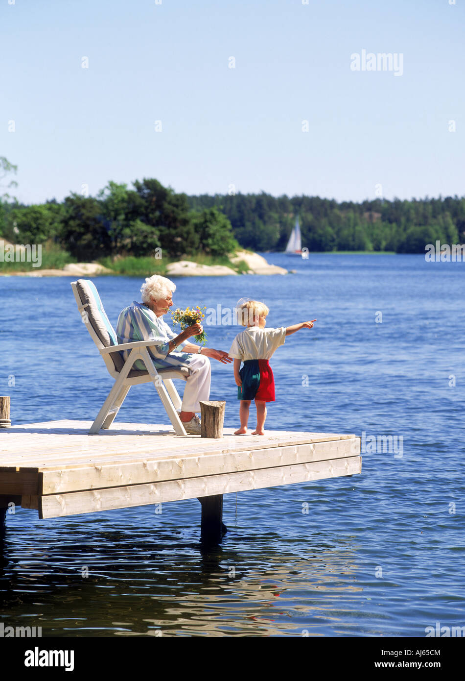 Grandmother with grandson on summer house dock in Stockholm Archipelago Sweden Stock Photo