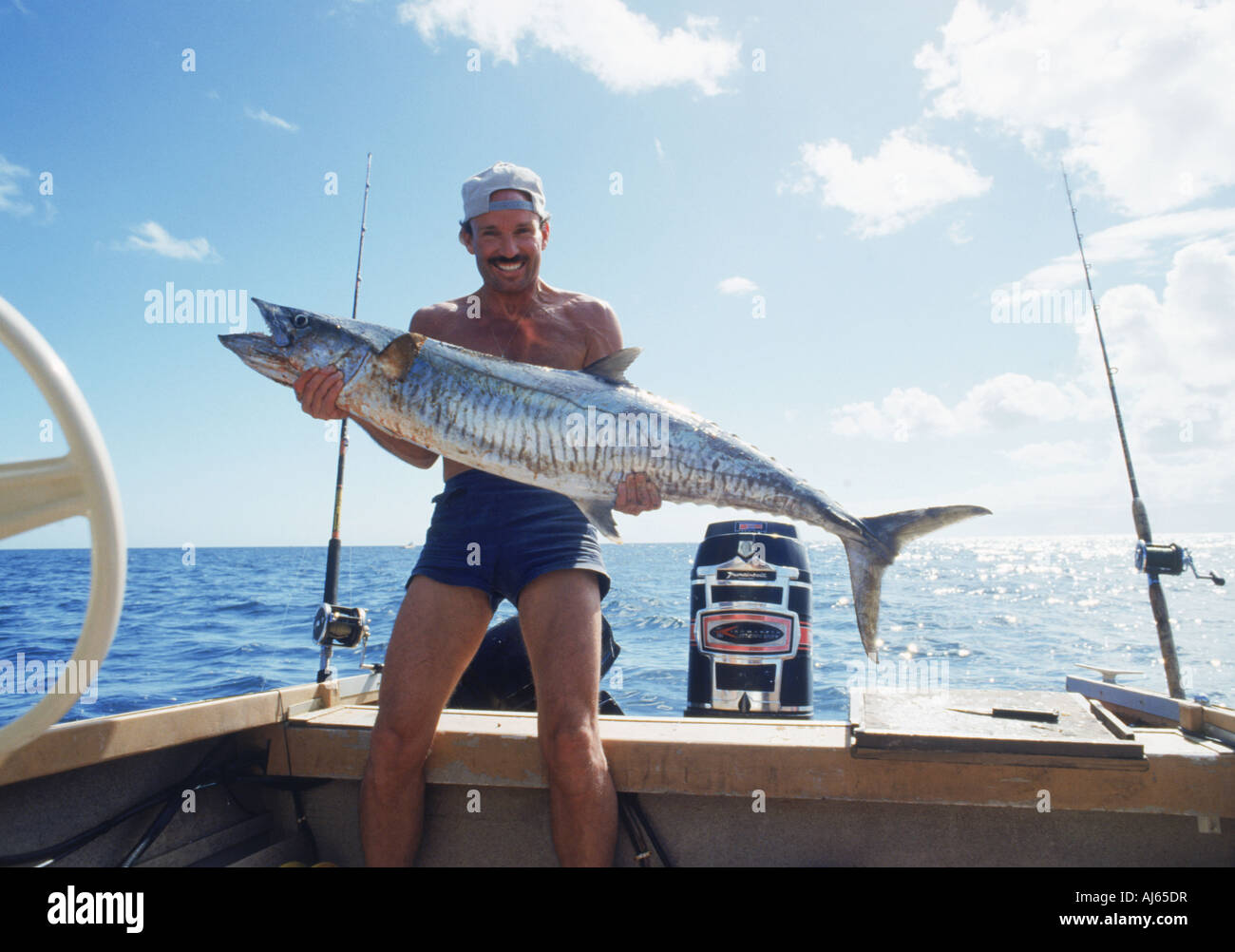 Fisherman holding large Spanish mackerel off Fraser Island in Australia