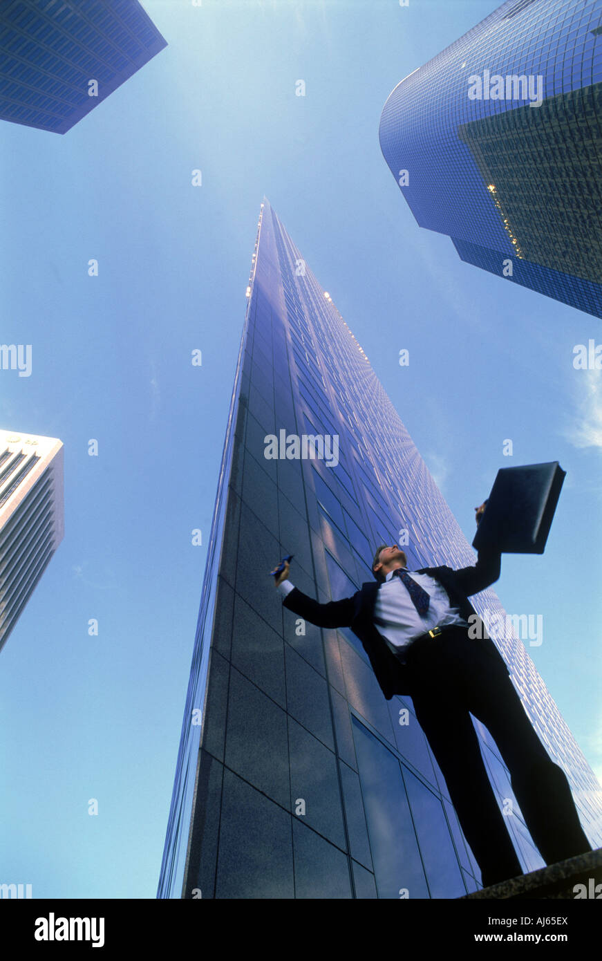 Businessman feeling victorious under Los Angeles skyscrapers in downtown Civic Center Stock Photo