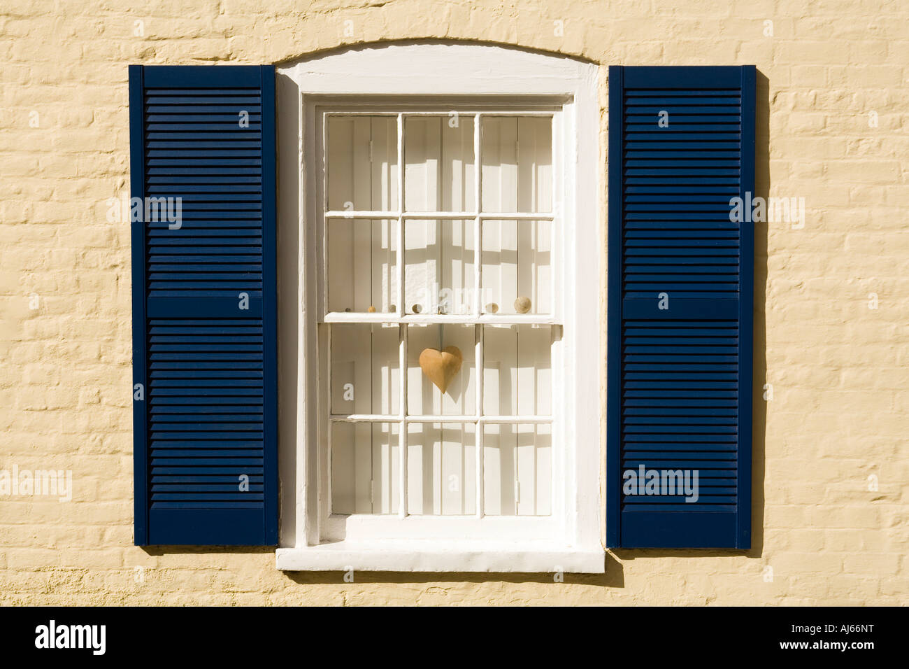 UK Kent Deal Old Town Middle Street wooden heart hanging in window with blue shutters Stock Photo